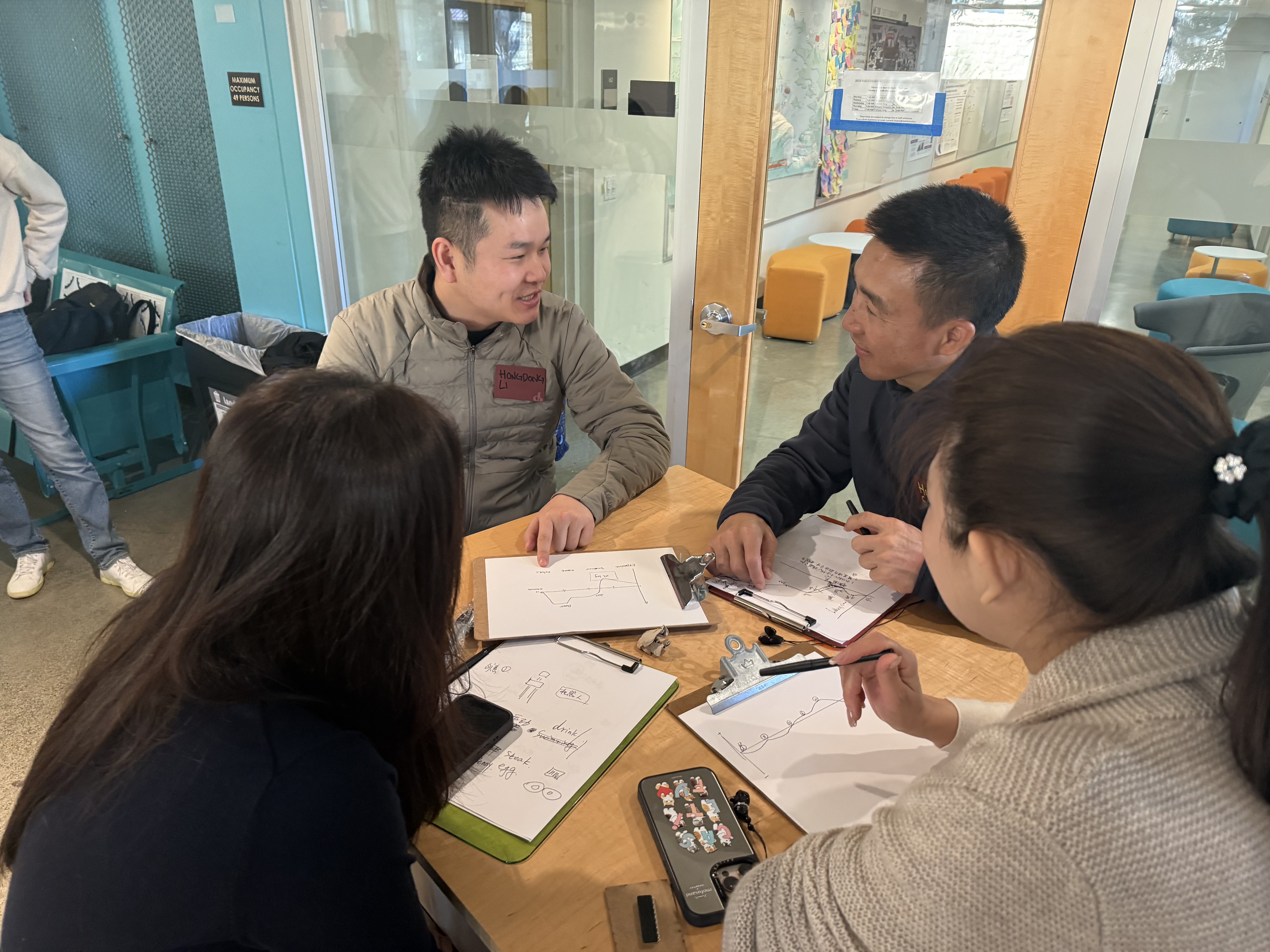Participants working on design thinking exercises in small groups at the Stanford d.school